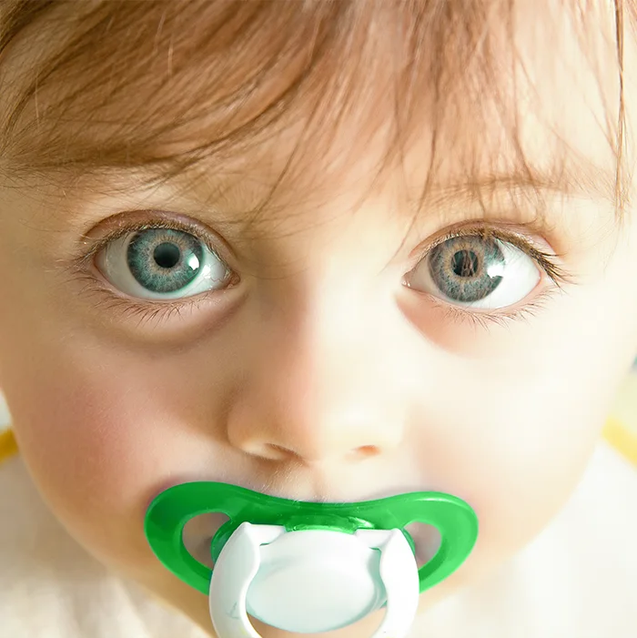 Enfant avec une suce verte, photo de la page éducative originale de la clinique